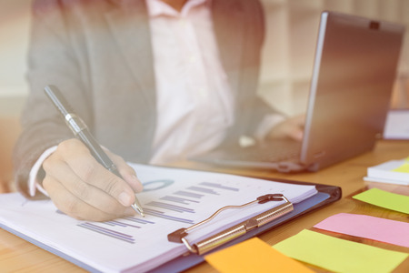 Business woman analyzing income charts and graphs with modern laptop computer. Business analysis and strategy concept.の写真素材