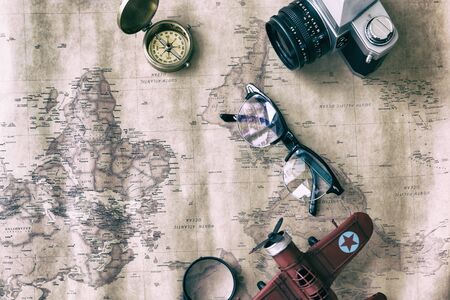 Tourism planning and apparel equipment needed for the trip on old map. Travel accessories, eyeglasses, camera, compass - vintage retro toneの写真素材