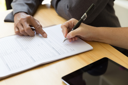 Person's hand hold ballpoint pen writing on blank application form paper sheet, fill in empty document template, applying for auto car insuranceの写真素材