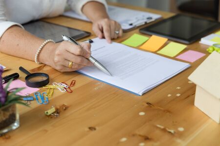 hands of an insurer or real estate agent showing mortgage loan agreement contract documents. Concept of home protection, family, insurance,rent houseの写真素材