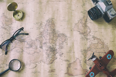 Tourism planning and apparel equipment needed for the trip on old map. Travel accessories, eyeglasses, camera, compass - vintage retro toneの写真素材