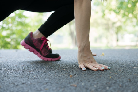 breathless sportswoman athletic on starting point and ready for competition. Healthy young asian athlete woman ready for race in park.の写真素材