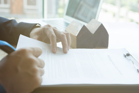 realtor man explain mortgage loan agreement to his client.  real estate agent or house developer...