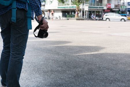 Chiang Mai, Thailand - June 29, 2017: young asian man wearing blue shirt and jeans with camera and backpack standing on footpath at Tapae gate in Chiang Mai, Thailand on June 29, 2017.のeditorial素材