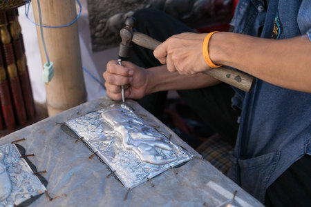 Chiang Mai, Thailand - July 1, 2017: Silversmith craftsman carving elephant on a silver plate (metal...