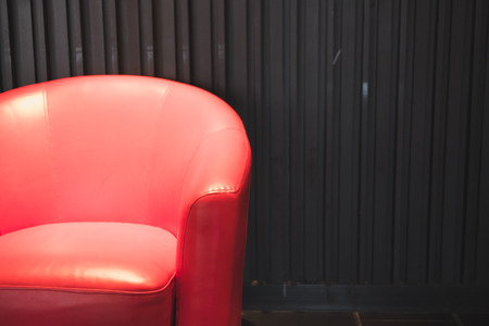red leather armchair beside black wall in living roomの写真素材