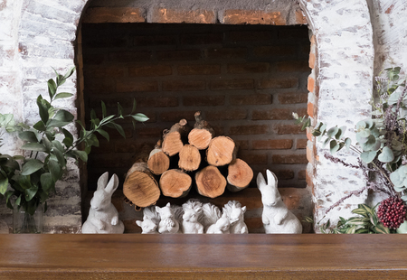 firewood in decorated brick fireplace with selected focus wood table for montage or display your productの写真素材