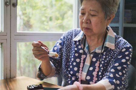 elder senoir eating blueberry cheese cake at cafe. asian elderly woman sitting and tasting delicious dessert at restaurant.の写真素材