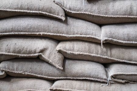 old hemp sacks containing coffee bean in warehouse. stacked sacks in storehouse.の写真素材