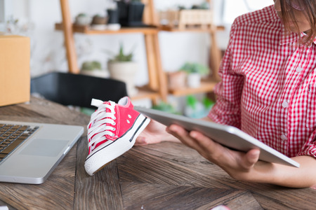 young start up small business owner working with digital tablet at workplace. freelance woman entrepreneur SME seller check product order to prepare for delivery to customers.  Online selling, internet marketing, e-commerce, shipping conceptの写真素材