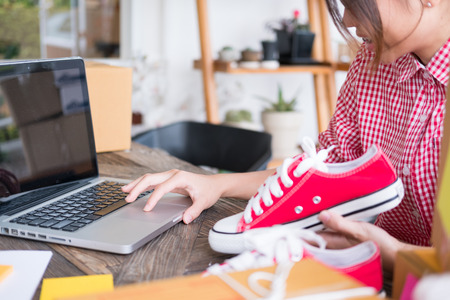 young start up small business owner packing cardboard box at workplace. freelance woman entrepreneur SME seller prepare parcel box of product for deliver to customer.  Online selling, internet marketing, e-commerce, shipping conceptの写真素材