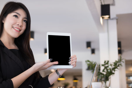 businesswoman hold digital tablet at workplace. young woman shows information in touchpad at office....