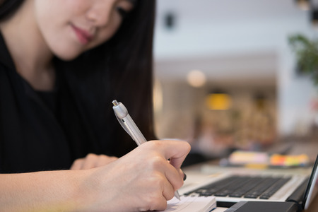 young businesswoman work with laptop at office. business person use computer at workplace. woman freelancer write note on notebook at cafe coffee shop.の写真素材