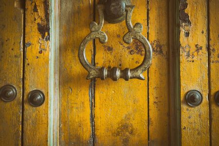 vintage retro style yellow wood door. old grunge brass doorknob. abstract backgroundの写真素材