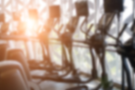fitness facility center, gym interior, health club with sports training equipment for aerobic exercise workout and bodybuilding, blurry defocused backgroundの写真素材