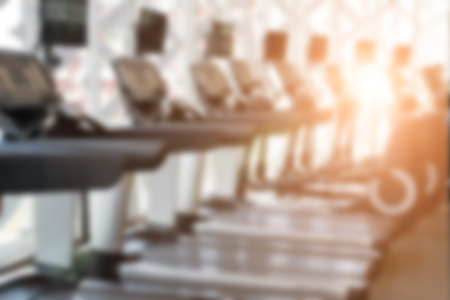 fitness facility center, gym interior, health club with sports training equipment for aerobic exercise workout and bodybuilding, blurry defocused backgroundの写真素材