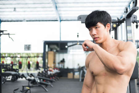 young man athlete prepare for training in gym. bodybuilder male working out in fitness center. sport guy doing exercises in health club.の写真素材