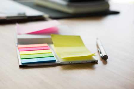 sticky note, ballpoint pen, notebook on wood office desk. business, workplace, education concept....