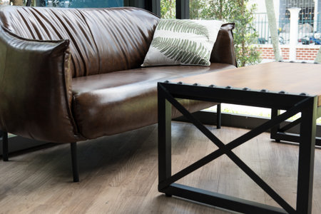 wood table, chair, brown leather sofa near window at restaurant or cafe coffee shopの写真素材