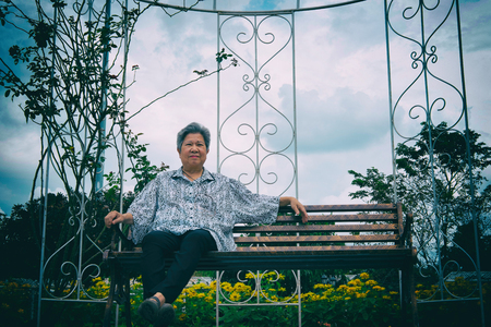 Asian elder woman resting in garden.の写真素材