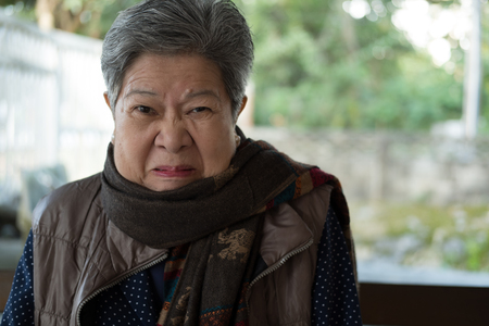 portrait of furious elder woman, enraged elderly female, angry asian seniorの写真素材