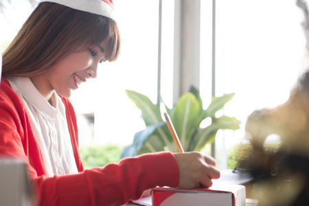 start up small business owner writing address on cardboard box at workplace. woman SME seller prepare parcel box of product for deliver to customer.  Online selling, e-commerce, shipping conceptの写真素材