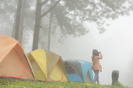 Tourist take photo near tent in mistの写真素材