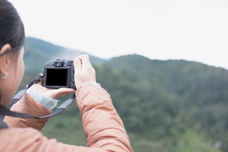 tourist use camera to take photo of mountain view. people, travel, nature concept.の写真素材