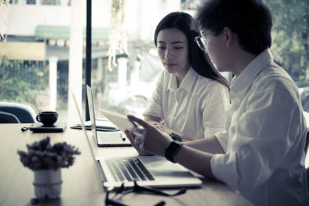 young business people having a meeting in office. businessman & businesswoman working together at workplace. startup man & woman have a discussion. Conference, teamwork, collaboration, corporate concept.の写真素材
