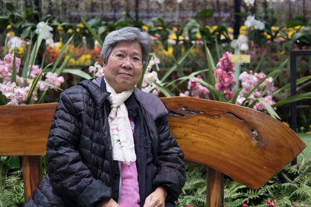 asian elder woman resting in garden. elderly female relaxing in park. senior leisure lifestyle...