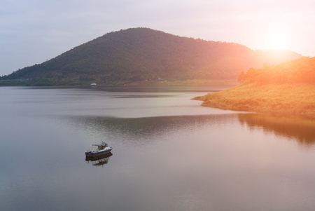 landscape of boat in dam & forest on mountain. serene lake sceneryの写真素材