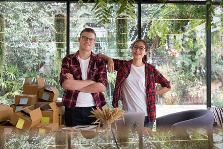 start up small business owner smiling at workplace. freelance man & woman seller posing at their shop.  Online selling, e-commerce, shipping conceptの写真素材