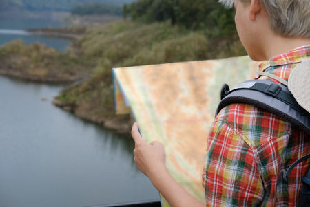 traveler man with map, backpack travel traveler man with map, backpack travel at forest & lake in summer. tourist backpacker relaxing outdoor. hiking lifestyle & vacation conceptの写真素材