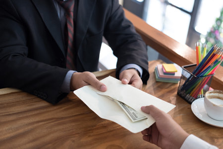 Businessman receiving envelope with money banknote. hand giving cash banknote to man - bribery, corruption, venality conceptの写真素材