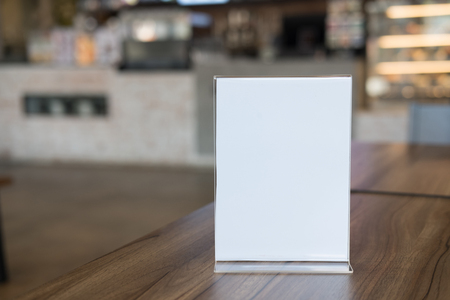 white label in cafe. display stand for acrylic tent card in coffee shop. mockup menu frame on table in bar restaurant. space for textの写真素材