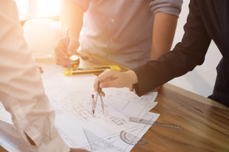 architect working on real estate project with partner at workplace. engineer discussing with colleague on living house blueprint at office.の写真素材