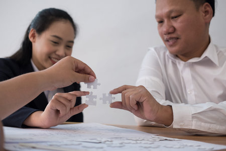 business people assembling piece of puzzle together. co worker team solving problem. unity teamwork...