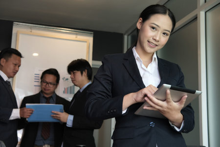 businesswoman smile at business meeting. young woman working on touchpad at office. female...
