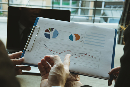 young business people having a meeting. businessman & businesswoman working with financial plan report at cafe. startup man & freelance woman discussing market data at coffee shop. discussion, teamwork, collaboration, corporate concept.の写真素材