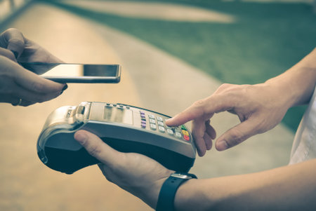 woman use smartphone to make mobile payment with electronic reader. customer paying with near field communication, NFC technology. people use app in mobile phone for online shopping.の写真素材