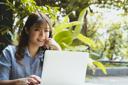 asian businesswoman working with computer in garden. freelance startup woman using laptop at home.の写真素材