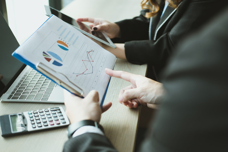 young business people having a meeting. businessman & businesswoman working with financial plan report at cafe. startup man & freelance woman discussing market data at coffee shop. discussion, teamwork, collaboration, corporate concept.の写真素材
