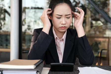 woman calculate domestic bills at home. Businesswoman using calculator at modern office. Young female checking balance and costs.  Startup counting finance for paying taxes. stressful, frustrated, upset conceptの写真素材