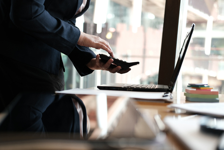 financial adviser working with calculator, business document & computer at office. accountant doing accounting & calculating revenue & budget. bookkeeper making calculation. finance & economy conceptの写真素材