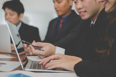 young business people having a meeting. businessman & businesswoman working with financial chart report. startup man & entrepreneur woman discussing market plan at workplace. discussion, teamwork, collaboration, corporate concept.の写真素材