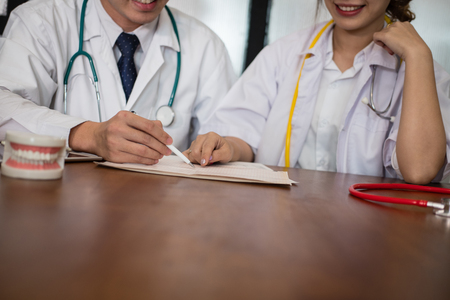 dentist co worker discussing patient teeth treatment with jaw teeth. orthodontist have meeting for diagnosis plan in conference room in hospital.の写真素材