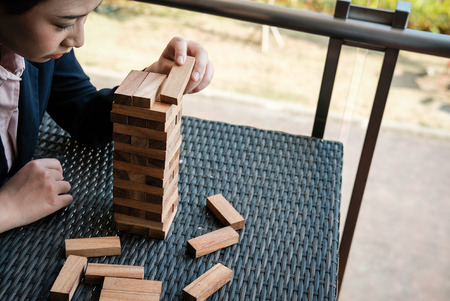 businesswoman hand placing wood block on tower. growth, risk & strategy in business.の写真素材