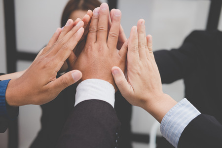 businessman joining united hand, business team touching hands together after complete a deal in meeting - unity, harmony, teamwork, partnership, collaboration, corporate concept.の写真素材