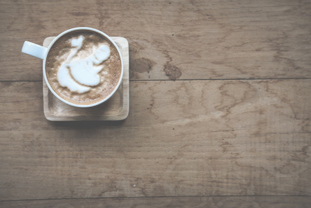 hot cappuccino coffee with milk topping in white cup on wood table in cafe - top viewの写真素材