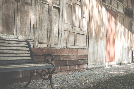 Wooden bench beside old wood house. chair in park. relax lifestyle conceptの写真素材